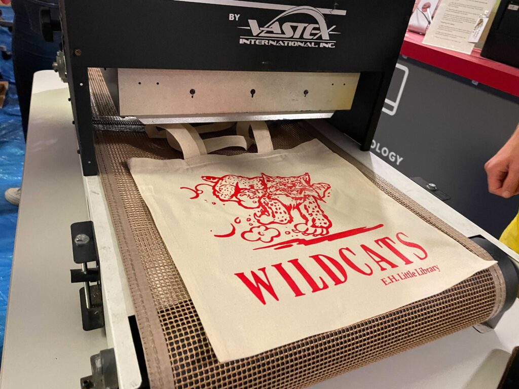 Wildcat tote bag on screen printing station. 